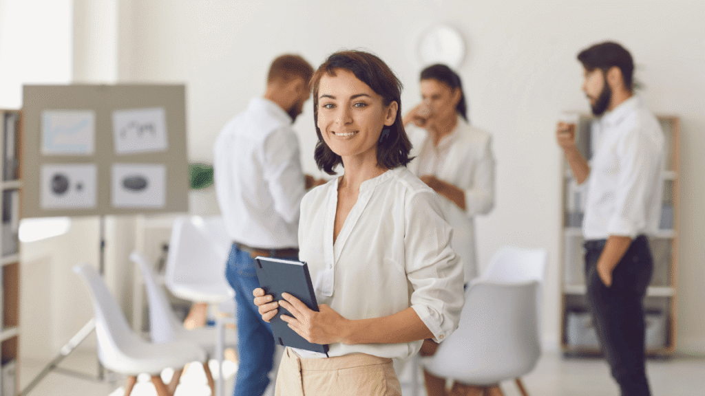 A woman stands confidently in front of a group of attentive people.
